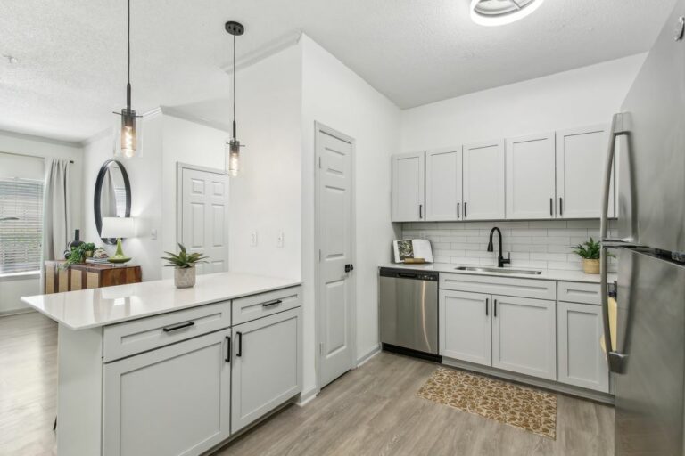 Renovated kitchen with white cabinets and stainless steel appliances.