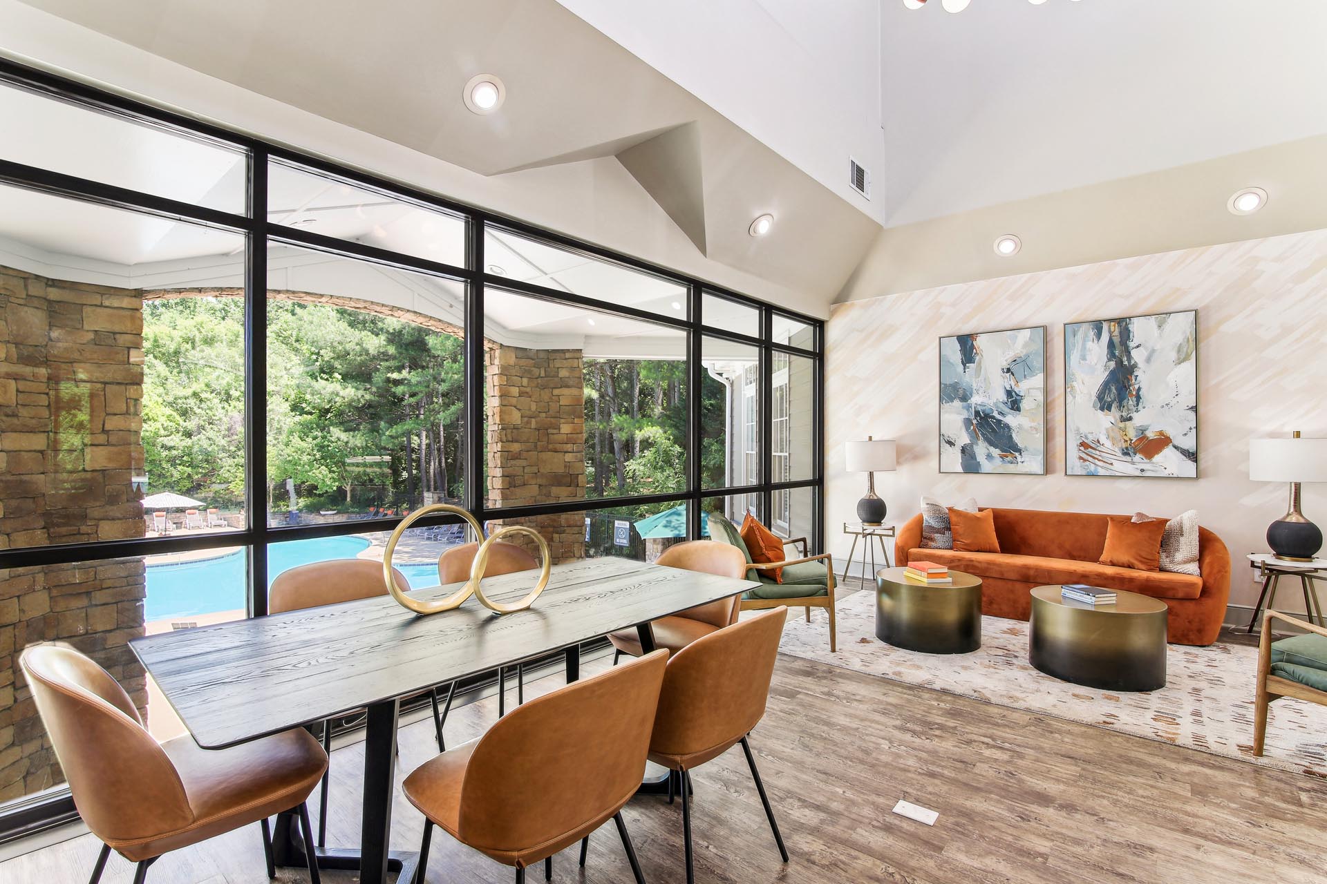 Clubroom with large table and seating area overlooking the swimming pool.